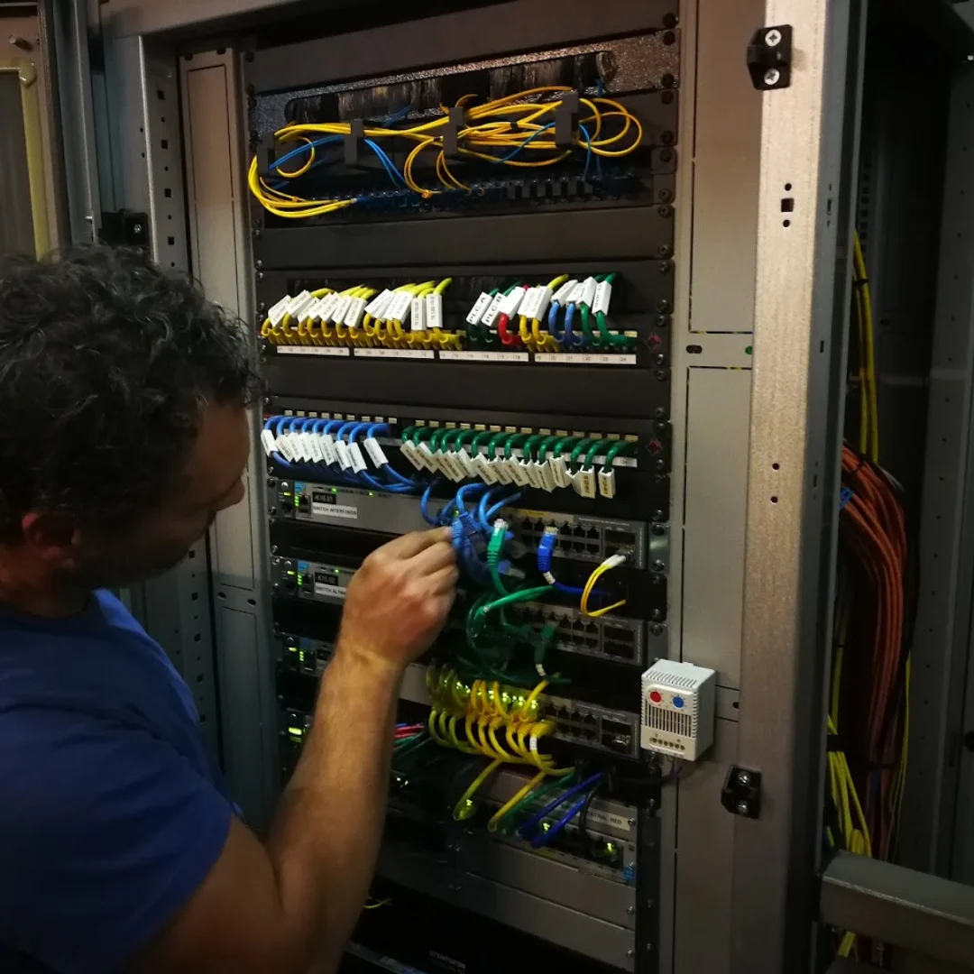 Tecnico installa e configura armadio rack 19 pollici con switch managed e patch panel per rete aziendale a Merano